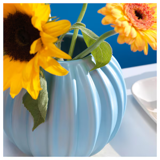 A decorative round vase from Ikea, filled with artificial flowers and perfect for low-maintenance home decor 