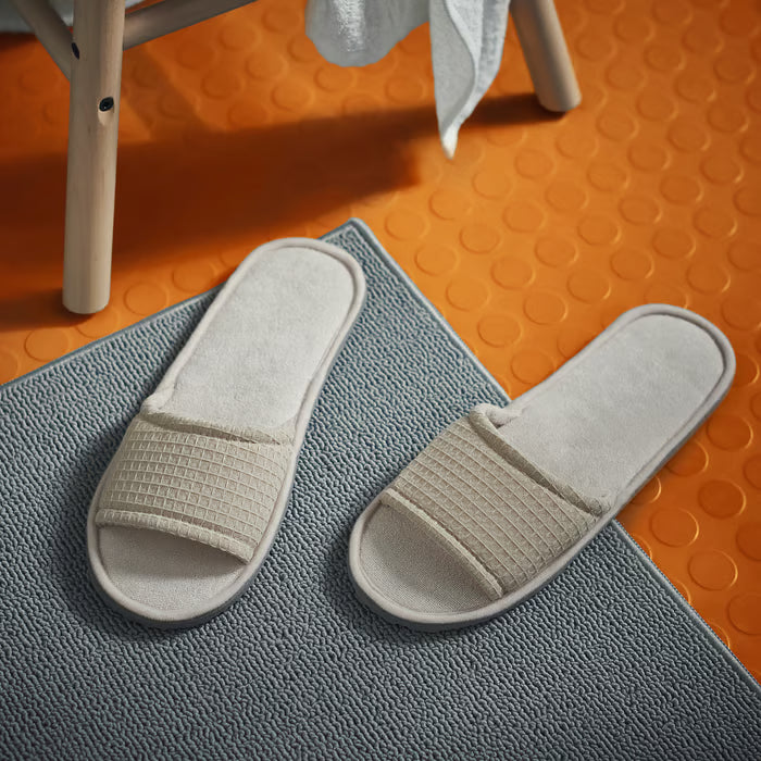 IKEA SKOVELSJÖN beige slippers worn in a cozy home setting on a wooden floor