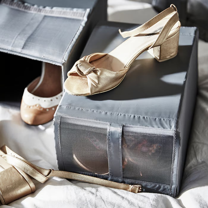 Gold heels placed on top of open IKEA SKUBB dark grey mesh shoe box