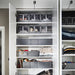 White wardrobe with IKEA SKUBB dark grey shoe boxes arranged neatly on shelves