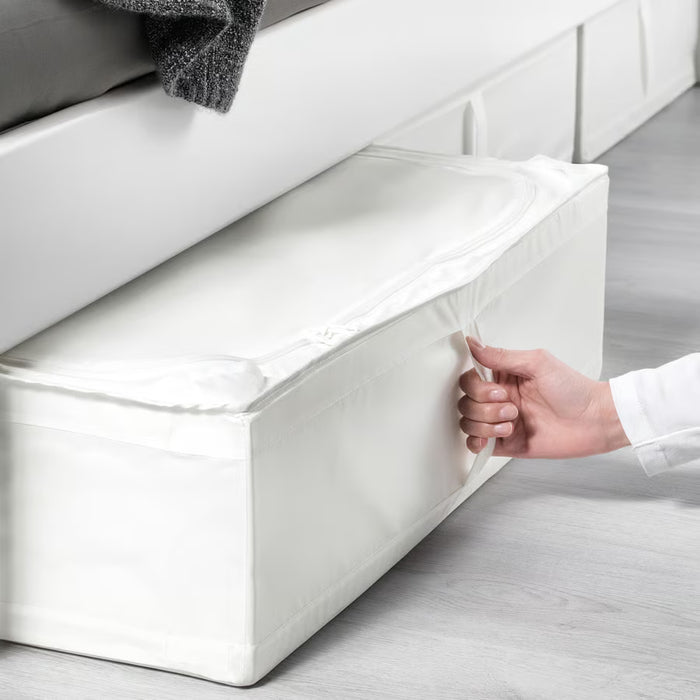 Hand pulling out IKEA SKUBB white storage case from under the bed using its built-in handle