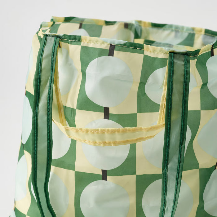 Close-up of IKEA SKYNKE pale yellow bag showing recycled polyester fabric texture and print
