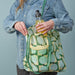IKEA SKYNKE pale yellow bag worn over shoulder showing long shoulder strap