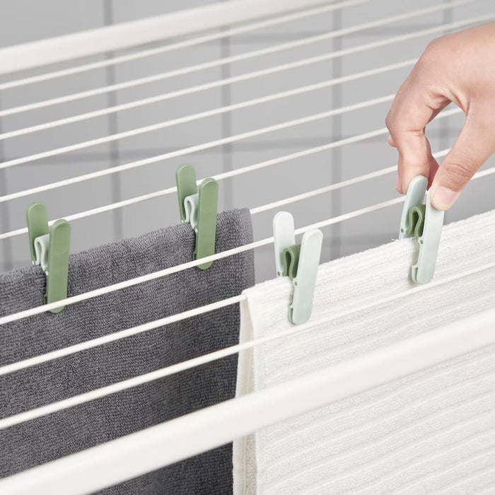 Bright green SLIBB clothes peg from IKEA, designed for hanging laundry securely