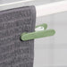 IKEA SLIBB clothes peg in green plastic with a rounded grip and firm spring, used for securing clothes to a drying line.