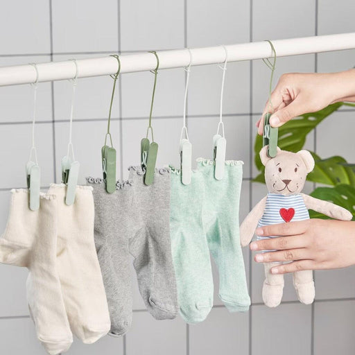  Person hanging socks using IKEA SLIBB green clothes pegs on a towel rail showing loop feature