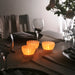 IKEA SMÅNÄCKROS white tealight holder glowing with lit candle, side view