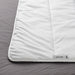 Close-up of IKEA SMÅSPORRE white duvet folded on grey bedsheet showing soft fluffy texture
