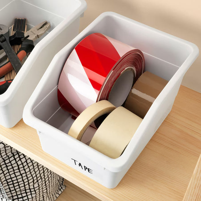 White SOCKERBIT box labelled tape holding red, white and beige tape rolls on wooden surface