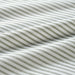 Close-up of IKEA SOLFIBBLA striped cotton flat sheet fabric showing weave and texture