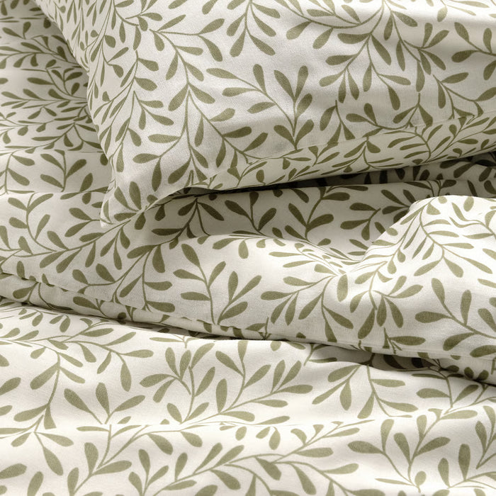Stacked IKEA SORGMANTEL white duvet cover and pillowcases with subtle green leaf pattern fabric texture