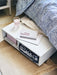 IKEA SORTSÖ natural cotton rug on floor beside bed with blue patterned bedding and white side table