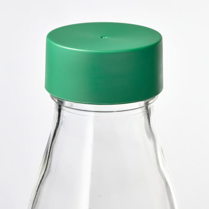 Close-up of IKEA SPARTANSK clear glass water bottle showing the green lid gasket
