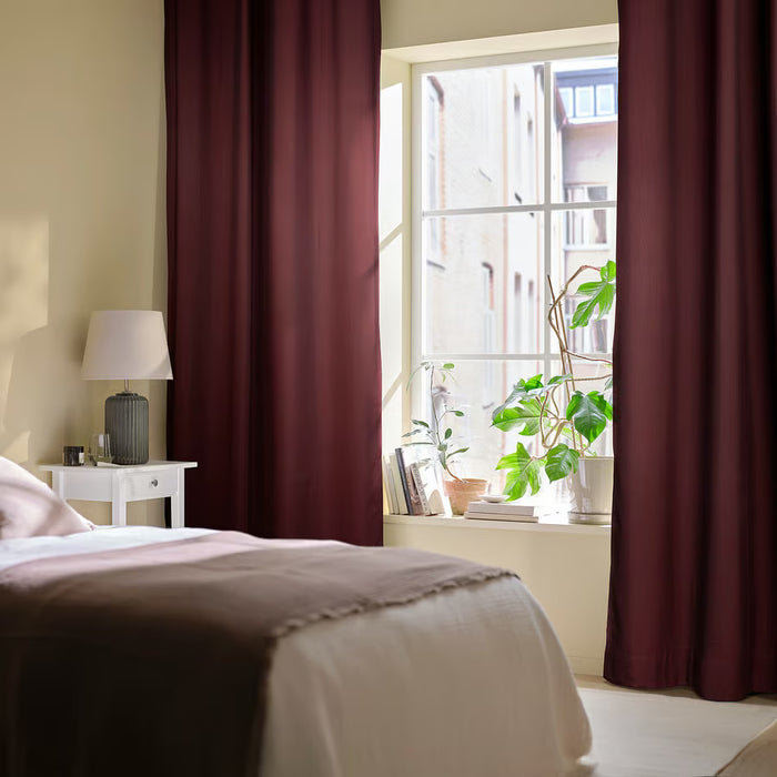  IKEA SPIRBJÖRNBÄR dark maroon curtains on large bedroom window with beige bedding and green plant