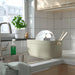  IKEA SPJUTLILJA dish drainer placed near kitchen sink with soap dispenser and green plant