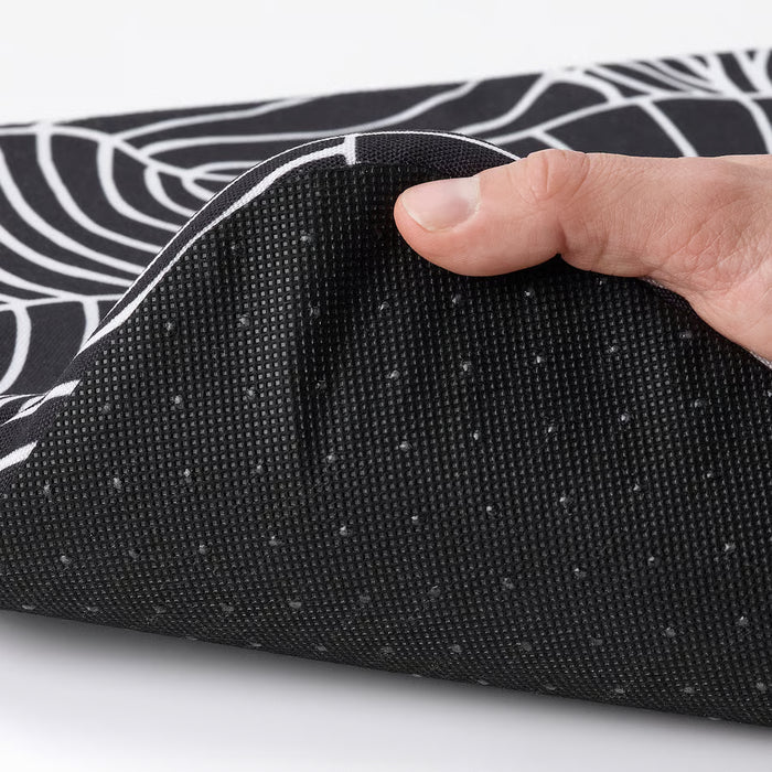 Hand holding IKEA STAGGSTARR black white chair pad showing foam filling and removable zip cover