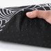 Hand holding IKEA STAGGSTARR black white chair pad showing foam filling and removable zip cover