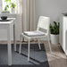 IKEA STAGGSTARR light grey chair pad placed on white dining chair beside a table in minimalist room