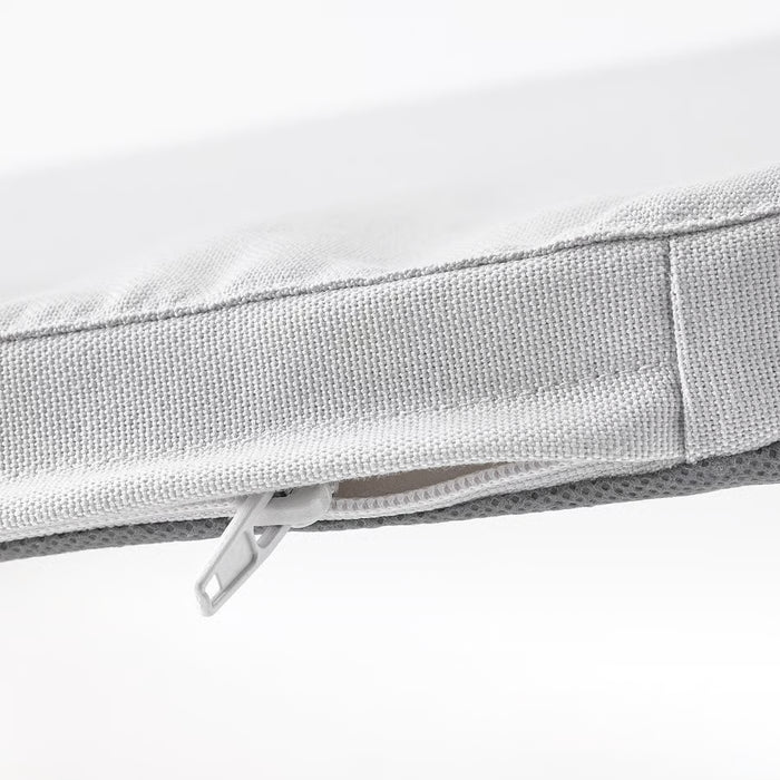 Close-up of IKEA STAGGSTARR light grey chair pad zip and textured polyester fabric detail