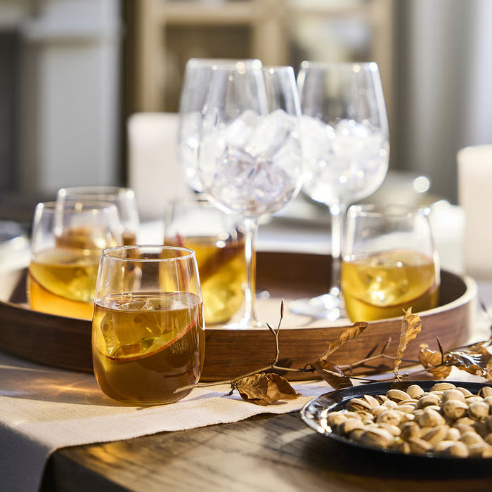 IKEA STORSINT clear glasses styled on a wooden tray with drinks, fruit slice, and decorative branches