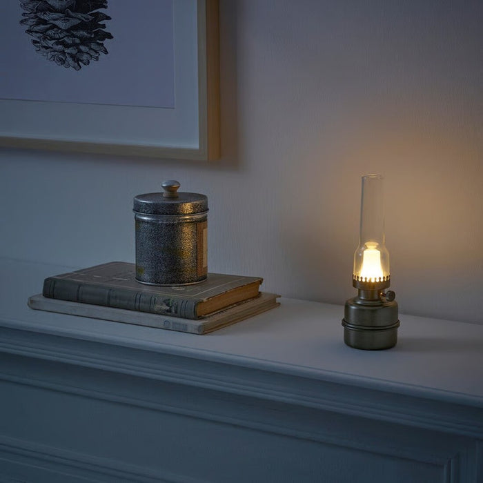 Small lamp on a shelf with decorative items in a dimly lit room