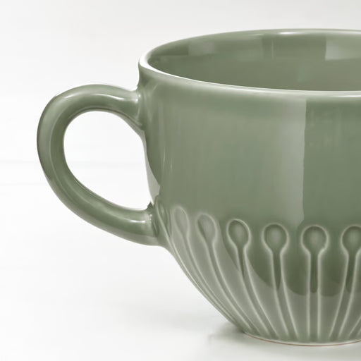 IKEA STRIMMIG stoneware mug pale grey-green close-up showing textured floral base and large handle 