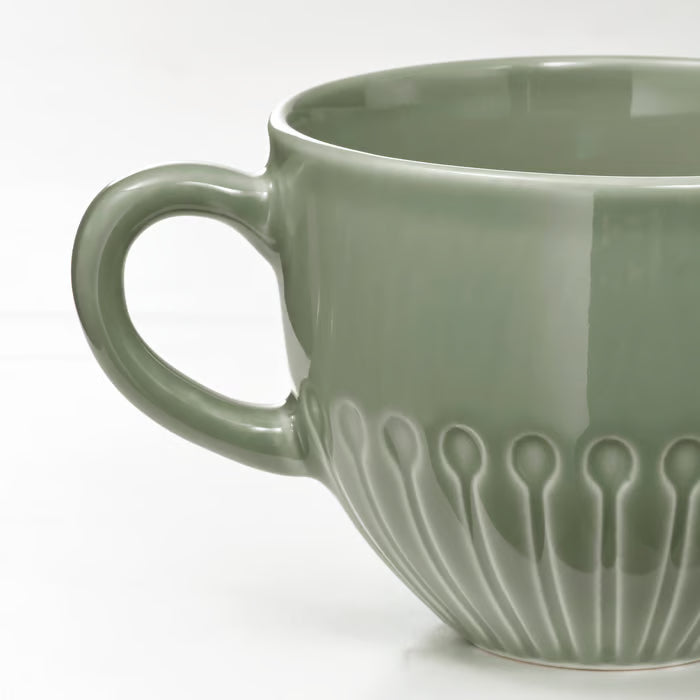 IKEA STRIMMIG stoneware mug pale grey-green close-up showing textured floral base and large handle 