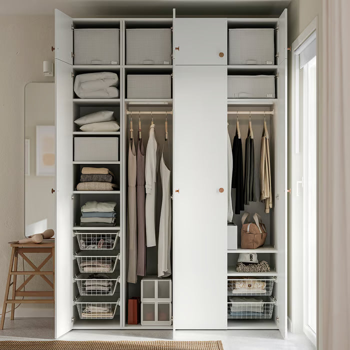 Open white wardrobe with IKEA STUK boxes holding folded clothes hangers and accessories organised on shelves