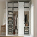 Open white wardrobe with IKEA STUK boxes holding folded clothes hangers and accessories organised on shelves