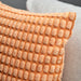 IKEA SVARTPOPPEL light orange cushion cover with soft patterned texture on bed close-up view