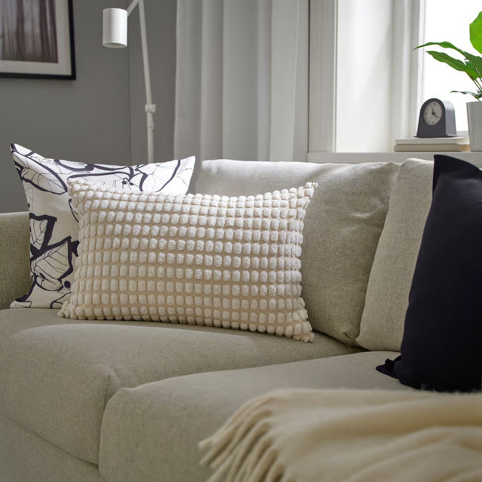 IKEA SVARTPOPPEL off-white cushion cover styled on a sofa with tufted texture visible