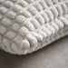 Close-up of IKEA SVARTPOPPEL off-white cushion cover showing tufted pattern and zip detail