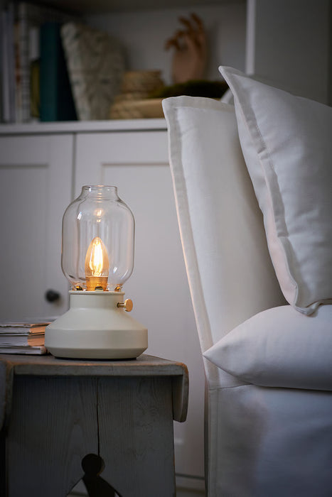 IKEA TÄRNABY beige glass table lamp on wooden bedside table beside white bed white background