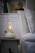IKEA TÄRNABY beige glass table lamp on wooden bedside table beside white bed white background