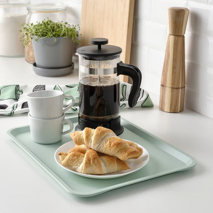 IKEA TILLGÅNG pale green tray holding coffee maker cups and pastries on kitchen counter