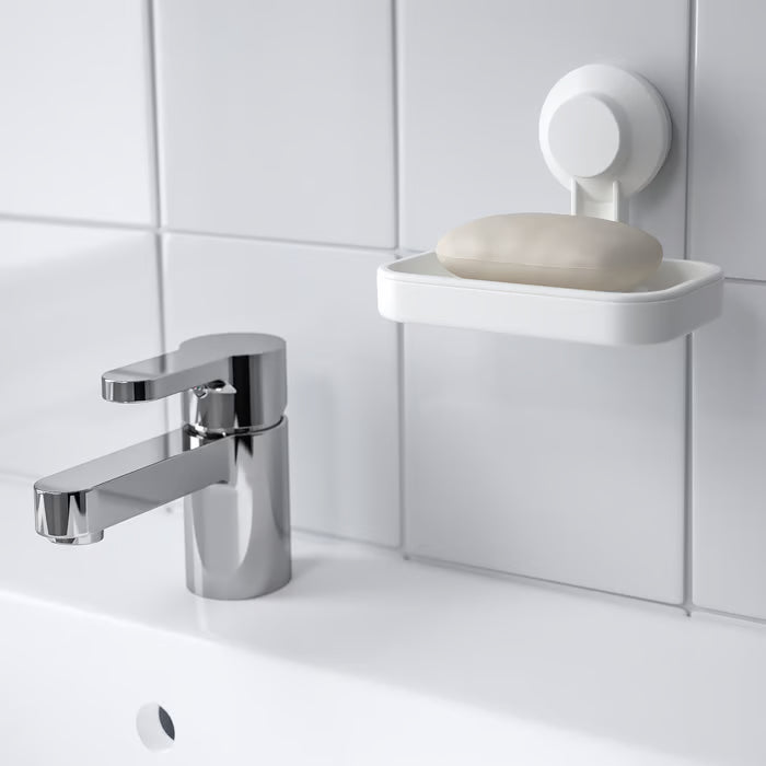  IKEA TISKEN white soap dish mounted on bathroom wall beside chrome tap with toothbrushes and plant