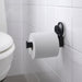 IKEA TISKEN black compact round toilet paper holder with a standard roll, mounted near a white toilet