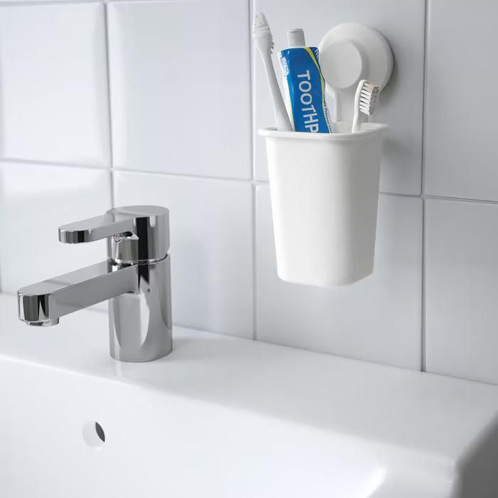 IKEA TISKEN white toothbrush holder suction cup holder shown with toothbrushes and toothpaste in bathroom setting