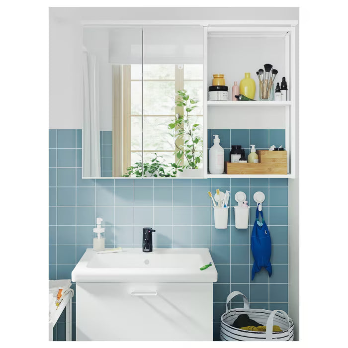 IKEA TISKEN white toothbrush holder mounted on mirror surface in compact bathroom