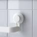 Close-up of IKEA TISKEN white suction cup mounted on tiled wall showing secure no-damage grip