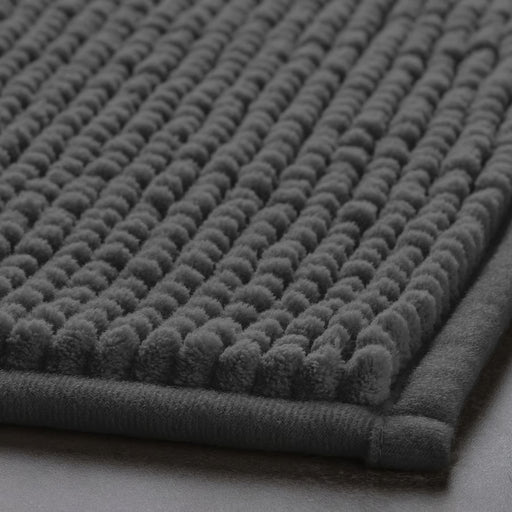 Close-up of IKEA TOFTBO grey bath mat with raised dot texture, soft and quick-drying