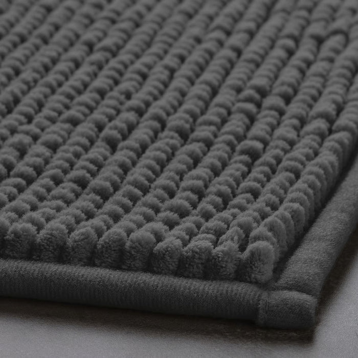 Close-up of IKEA TOFTBO grey bath mat with raised dot texture, soft and quick-drying