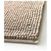 Close-up of IKEA TOFTBO beige bath mat showing raised bobbles and ribbed border edge