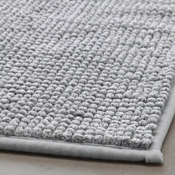 Close-up of IKEA TOFTBO grey-white bath mat folded showing soft microfibre surface texture