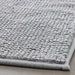 Close-up of IKEA TOFTBO grey-white bath mat folded showing soft microfibre surface texture