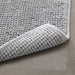 Underside of IKEA TOFTBO grey-white bath mat showing anti-slip mesh backing