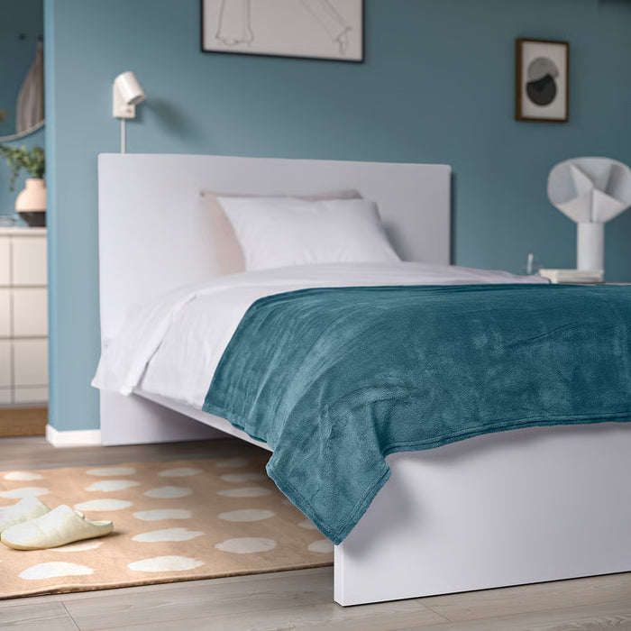 IKEA TRATTVIVA bedspread styled on a neatly made bed in a calming blue and white bedroom