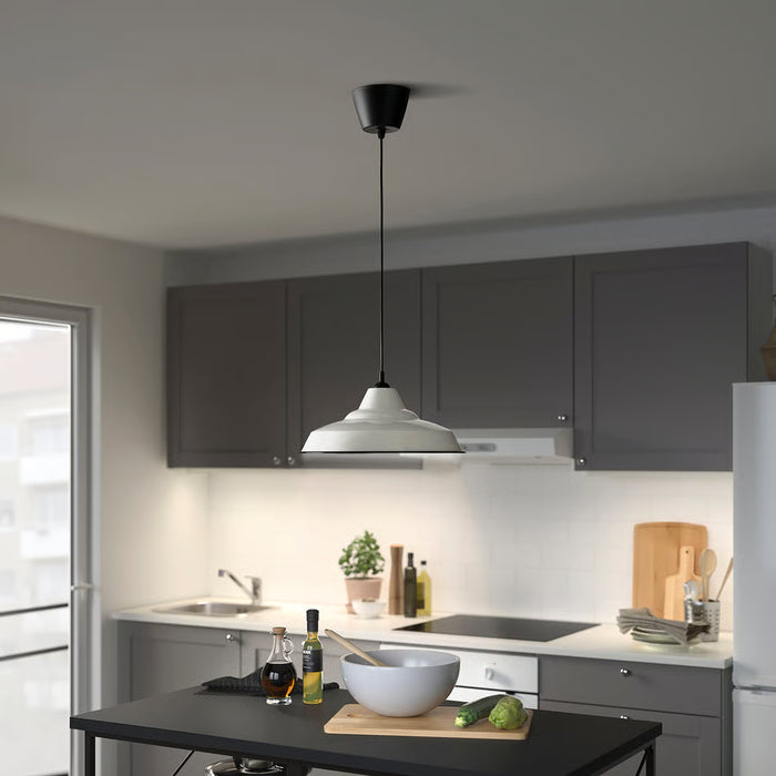 IKEA TRETTIOEN pendant lamp in black illuminating a kitchen counter with fresh vegetables