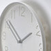 IKEA TROMMA white wall clock close-up of punched hole numerals and hands pointing to twelve and six