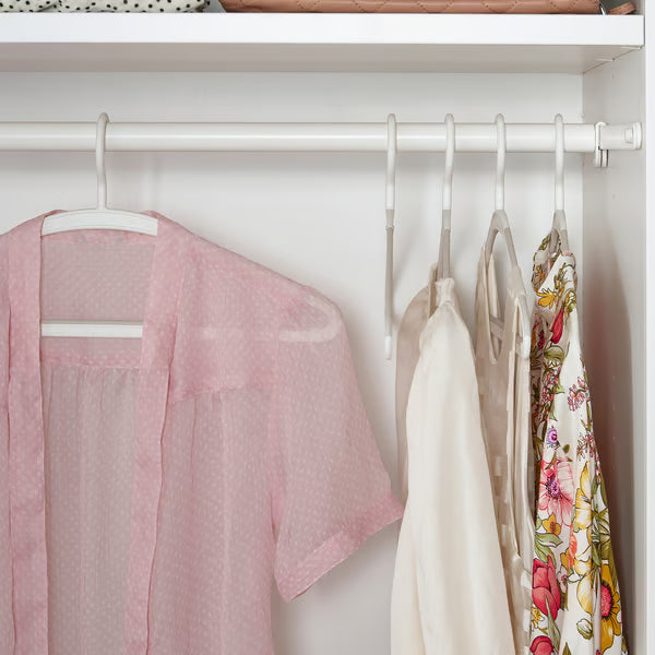 Assorted clothes hanging neatly in wardrobe on IKEA TRYSSE white anti-slip hangers organised closet